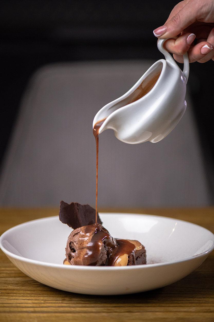 Chocolate poured on a dessert at Oxton Bar